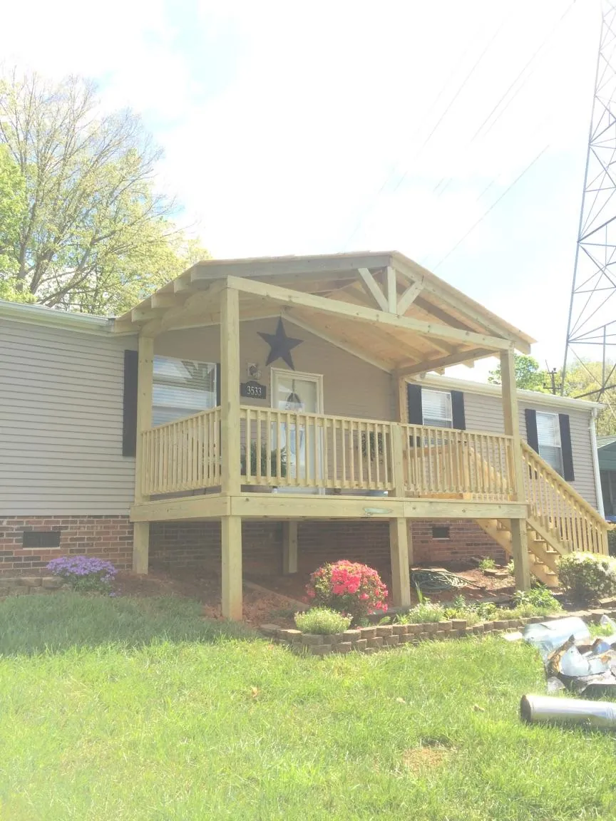 New gabled porch roof and deck railing added to a ranch home in Cygnet